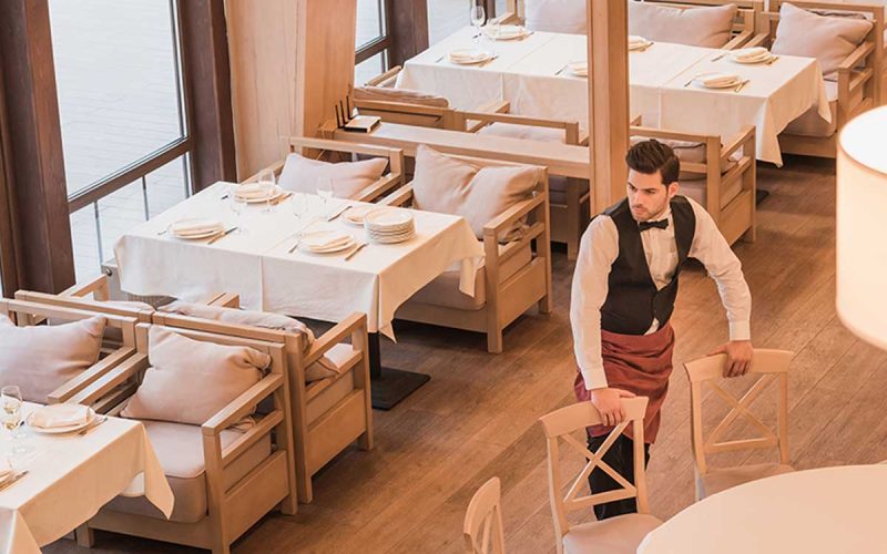 smart-digital-waiter-putting-chairs-around-table-in-a-restaurant